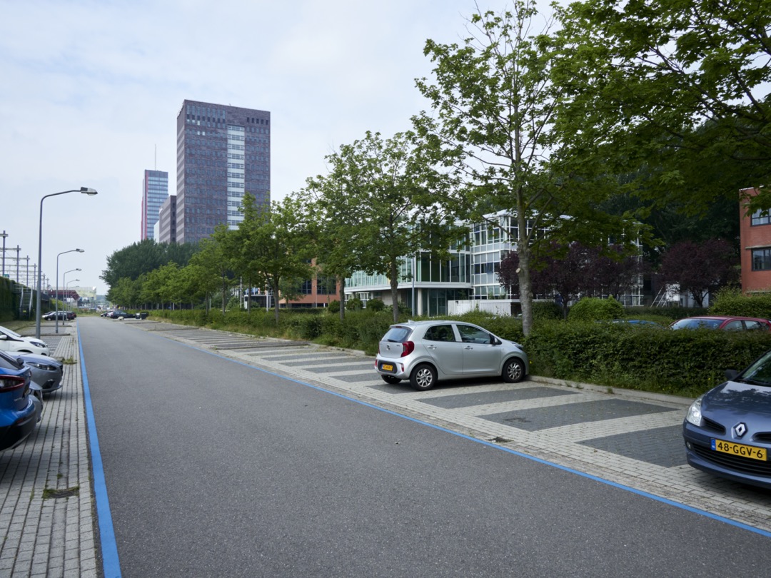 Foto van parkeerplaats op Randstad 20 met hoogbouw op achtergrond