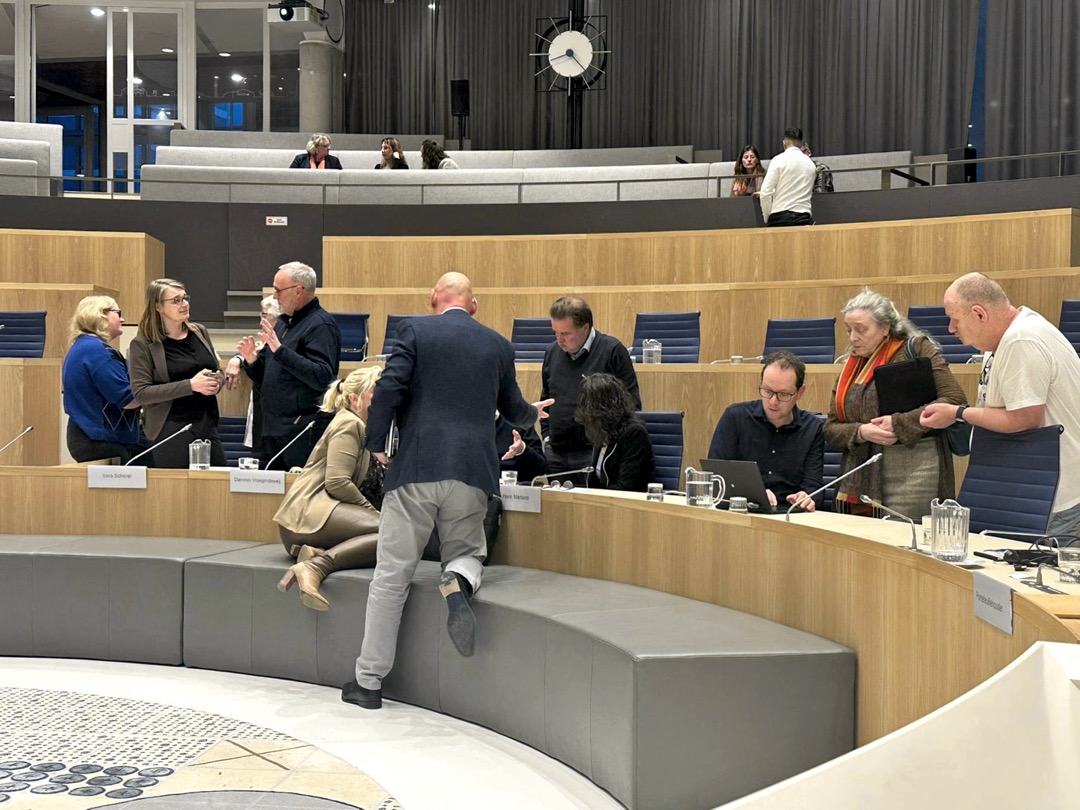 Foto van raadsleden en inwoners in gesprek in de raadzaal