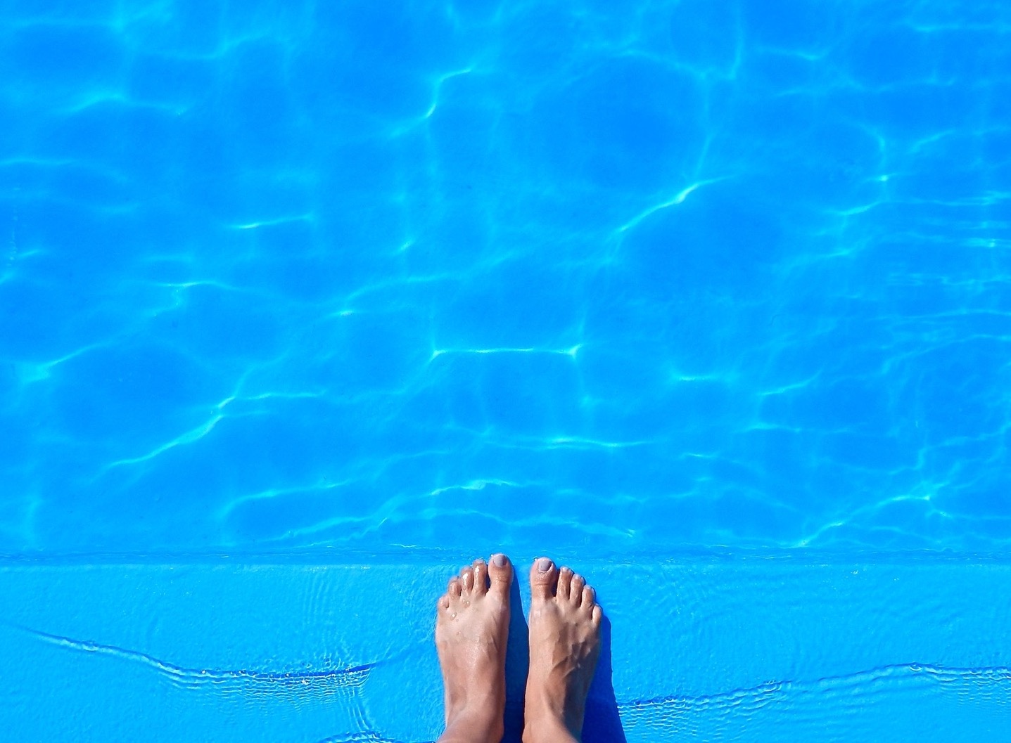 Afbeelding:Voeten op de rand van een zwembad